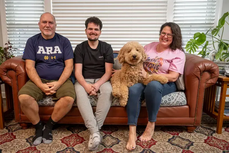 From left to right, Harry, Alec, Lucy (dog), and Gail Koujaian at home.