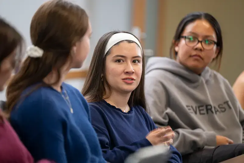Student Cassandra Bustillos sits in class between two students.