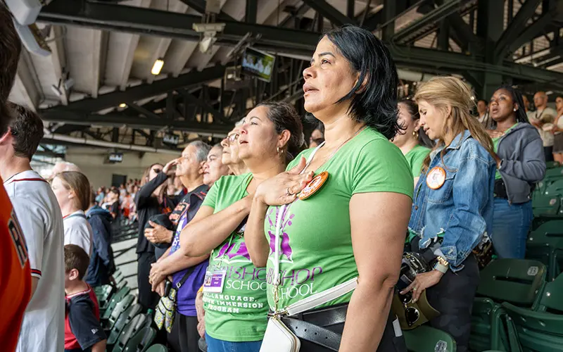 Maria Rodriguez sings the national anthem with the other teachers at the opening of the baseball game against the Baltimore Orioles and Atlanta Braves at Camden Yards in Baltimore, Maryland. 