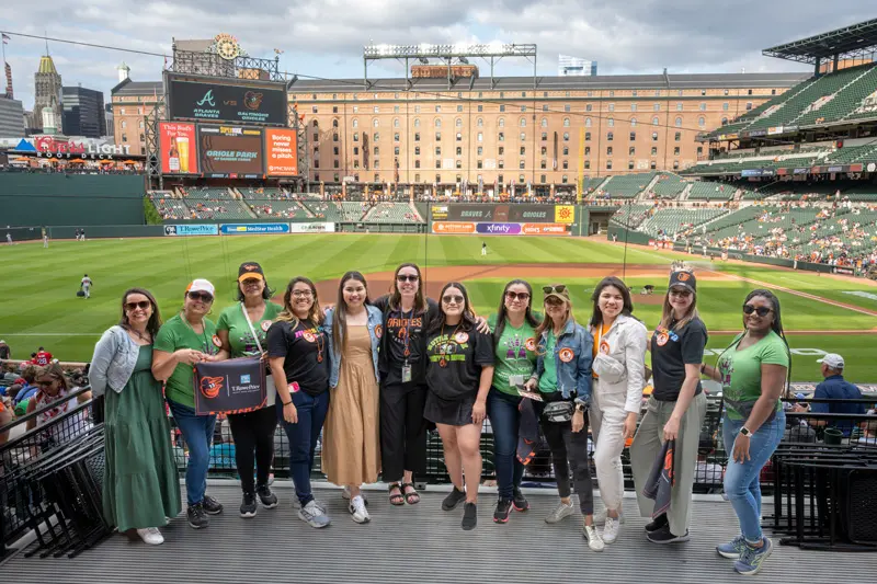 Eleven spanish immersion teachers and Claire Roach pose for a picture with Camden Yard in the background.