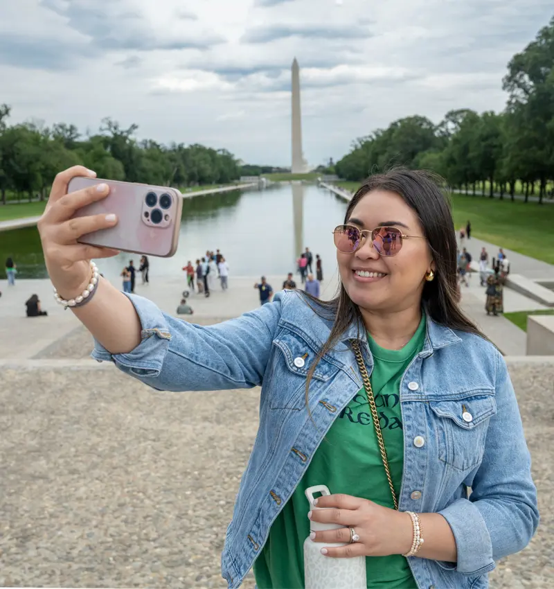 Zoadi Paguada takes a selfie while wearing sunglesse. In the background is the Washinton Monument.
