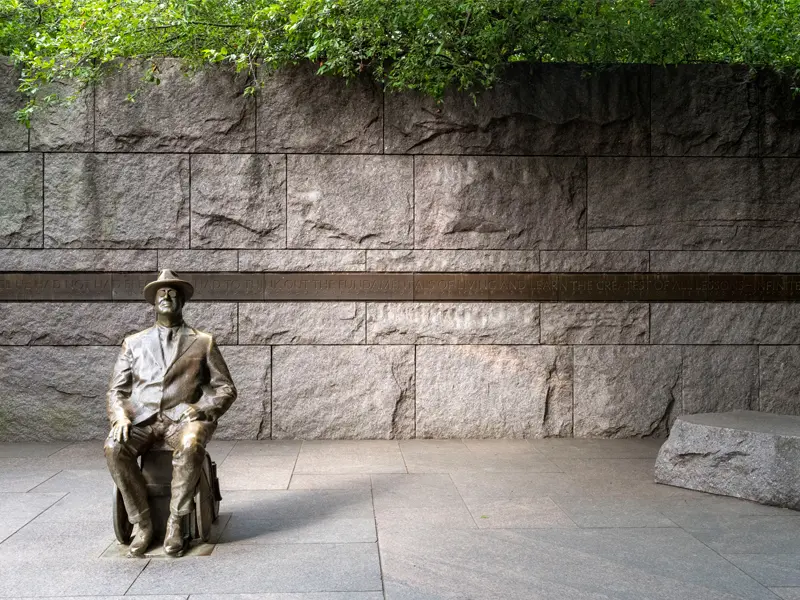 A statue of Franklin Delano Roosevelt sitting on a bench at his memorial in Washington, D.C.