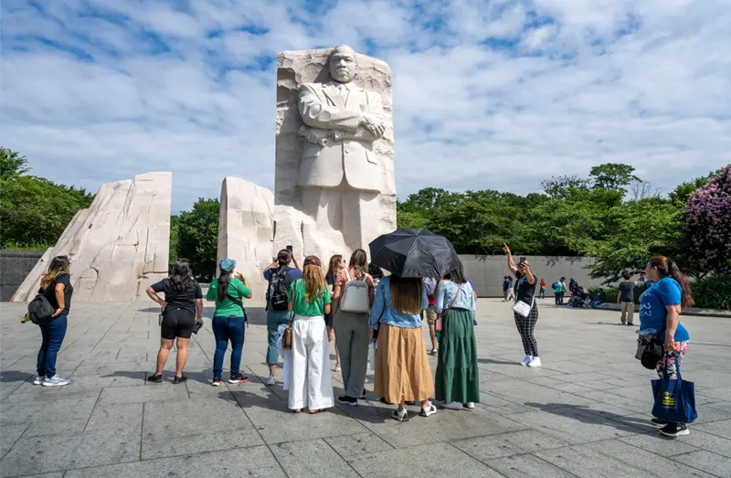 Teachers stand in front of the Stone of Hope granite state at the Martin Luther King Jr. Memorial in Washington, D.C.
