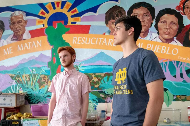 Francis Brockman, left, and Daniel Rottenborn stand in front of colorful mural in Casa Vides.