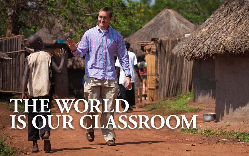 ISSLP student Mick Madden greets a boy in Gulu, Uganda.