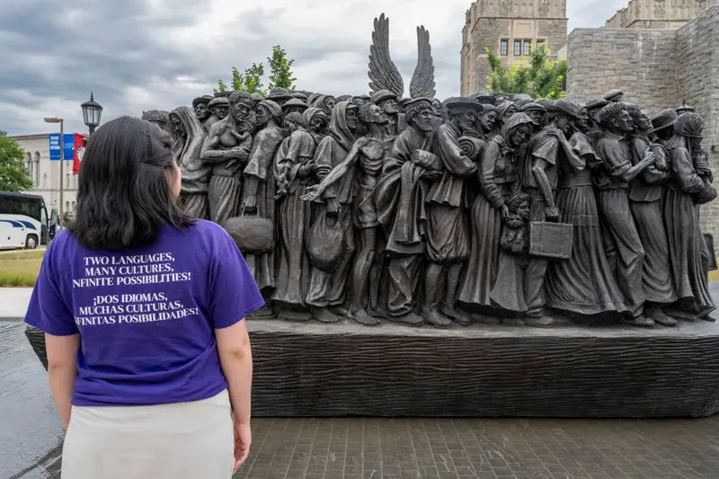 Elsy Pineda gazes at the Angels Unawares sculpture, a bronze sculpture of migrants and refugees from various lands crowded on a 20-foot boat at the Catholic University of America in Washington, D.C.