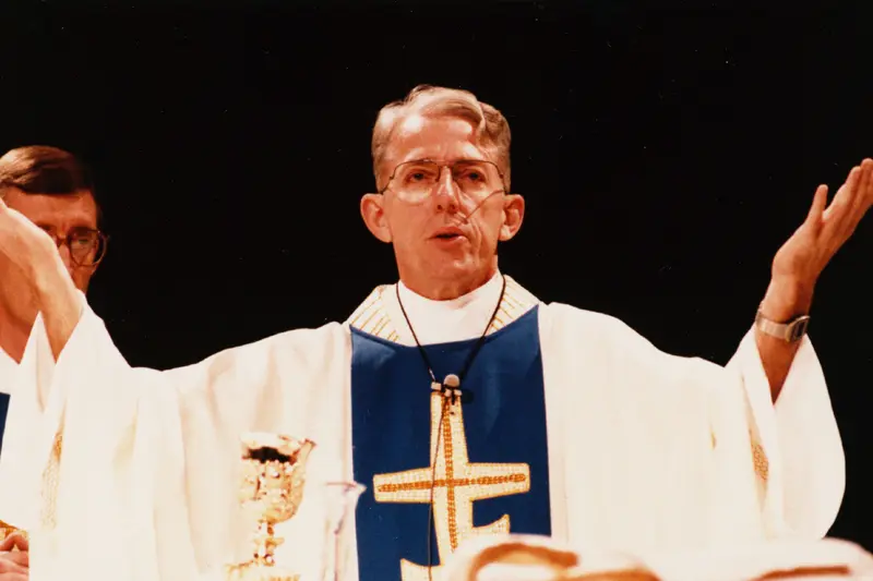 Fr. Malloy wears extends his hands in prayer at his inauguration Mass in 1987.