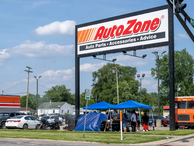 A blue canopy tent set up outside of an Auto Zone.