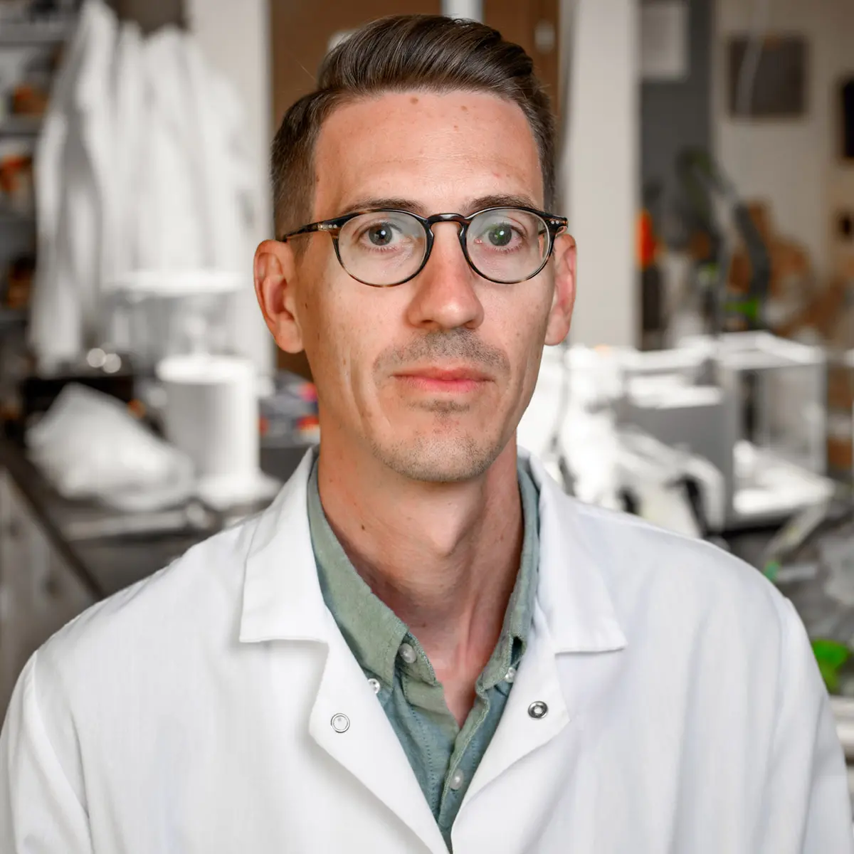 A portrait of Kyle Doudrick wearing a white lab coat.