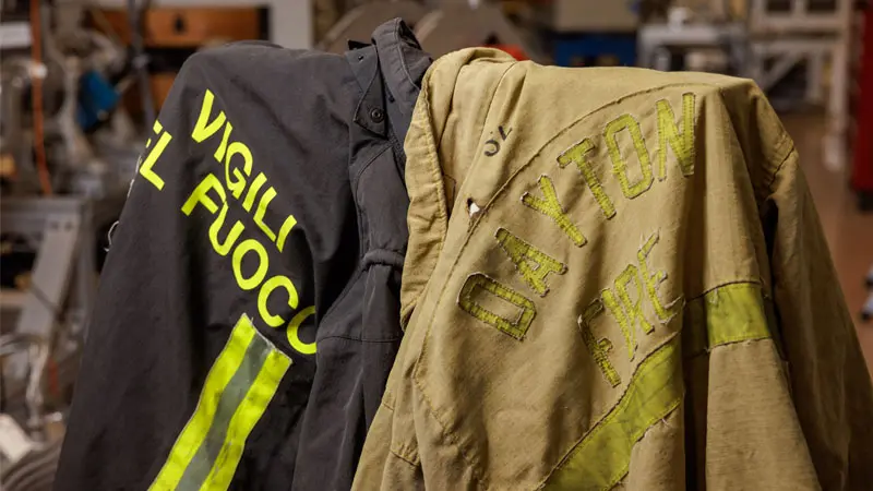 Two firefighter jackests - one black and one yellow.