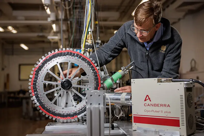 Graham Peaslee adjusts the smample wheel in his lab.