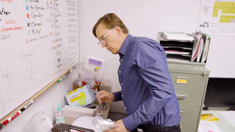 Graham Peaslee bends over some samples in his lab.