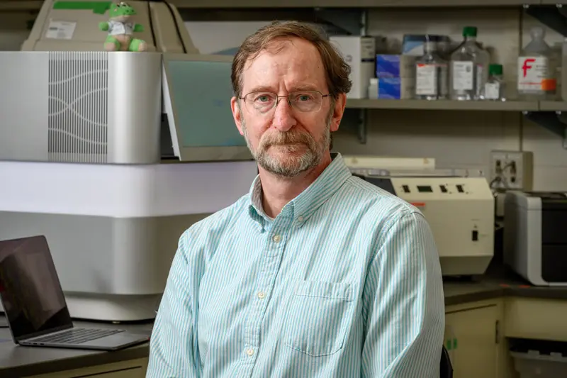 Portrait of Michael Pfrender sitting in his lab.