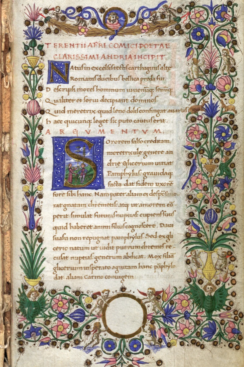 An illuminated manuscript page of Terence's *Andria*. The text is framed by elaborate floral borders interspersed with winged cherubs and small monkeys. A historiated initial 'N' and 'S' in blue and gold feature human figures within them. A circular cartouche at the bottom remains unfilled.