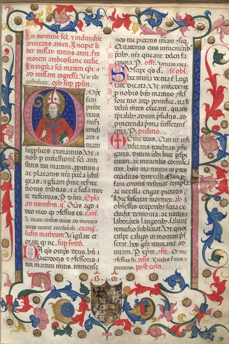 An illuminated manuscript page featuring a bishop in red and white robes holding a crosier in his left hand. The bishop is positioned within a circular frame against a blue background. The text is written in Latin, and the margins are decorated with floral designs and gold accents. A coat of arms is visible at the bottom of the page.