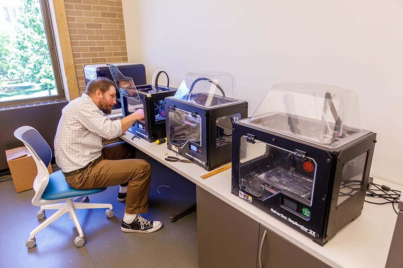 A man works with 3D printers.