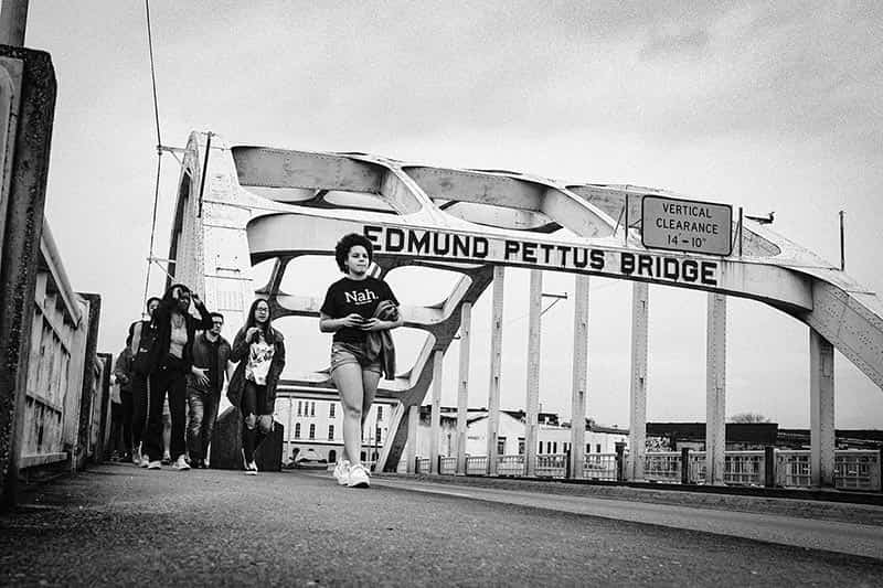 A group of students walk across the Edmund Pettus Bridge.