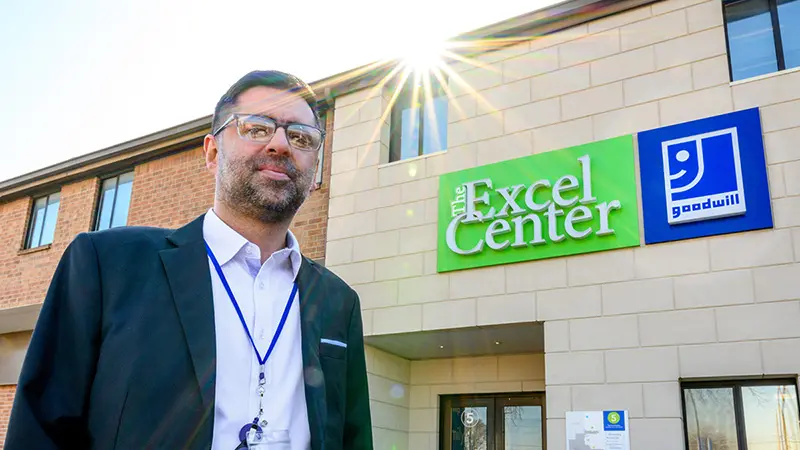 Rizan Hajji Mohamed stands in front of The Excel Center building in Indianapolis.