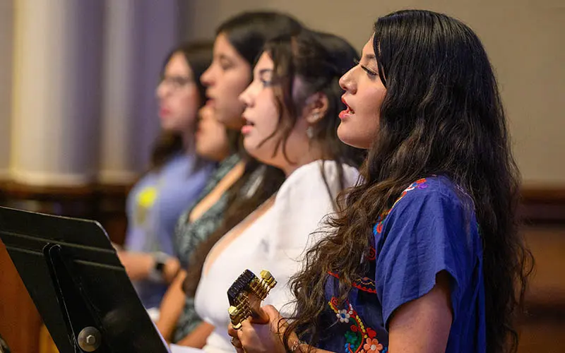 Five women of varying ethnicities sing at the Spanish Mass at the Basilica of the Sacred Heart.